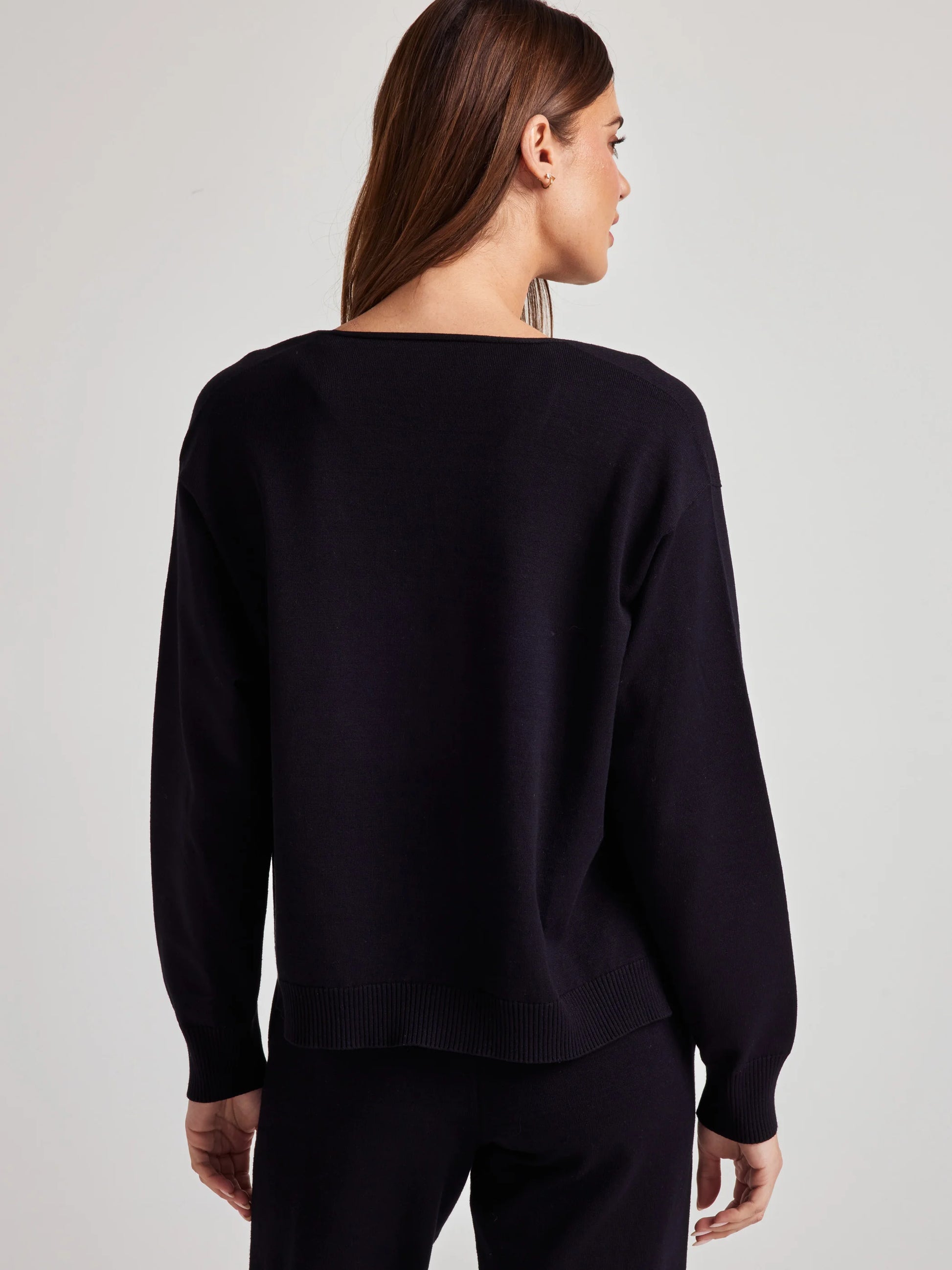 model wears sustainable cozy v neck sweater in black