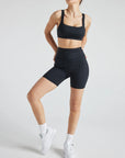 Model wears sustainable black nylon rib biker shorts