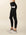 Model wears full length crossover deep pocket leggings in black and cream