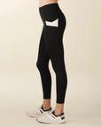 Model wears full length crossover deep pocket leggings in black and cream
