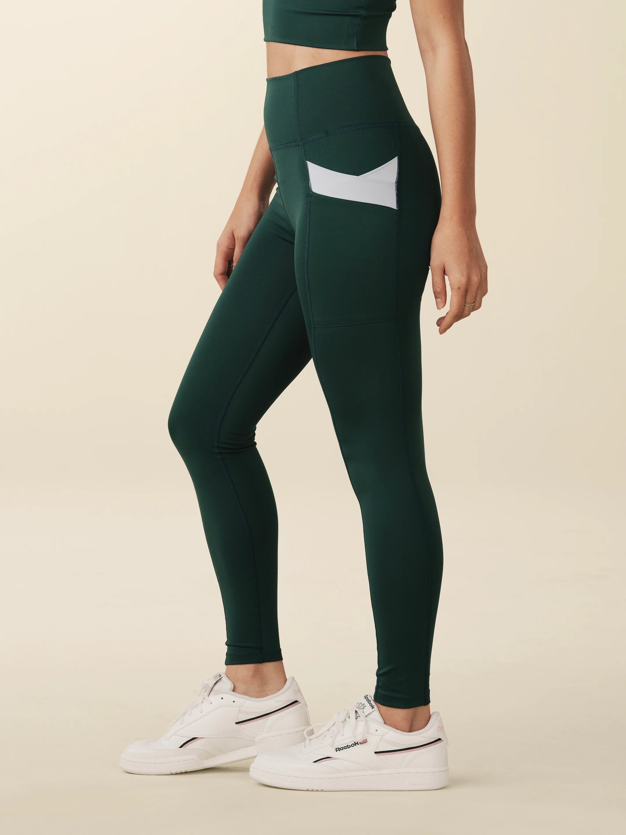 Model wears full length crossover deep pocket leggings in green and light blue