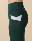 Model wears full length crossover deep pocket leggings in green and light blue