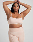 Model poses in ballet-pink bralette with corset boning