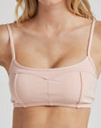 Model poses in ballet-pink bralette with corset boning