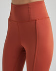 model poses in burnt orange leggings with corset boning