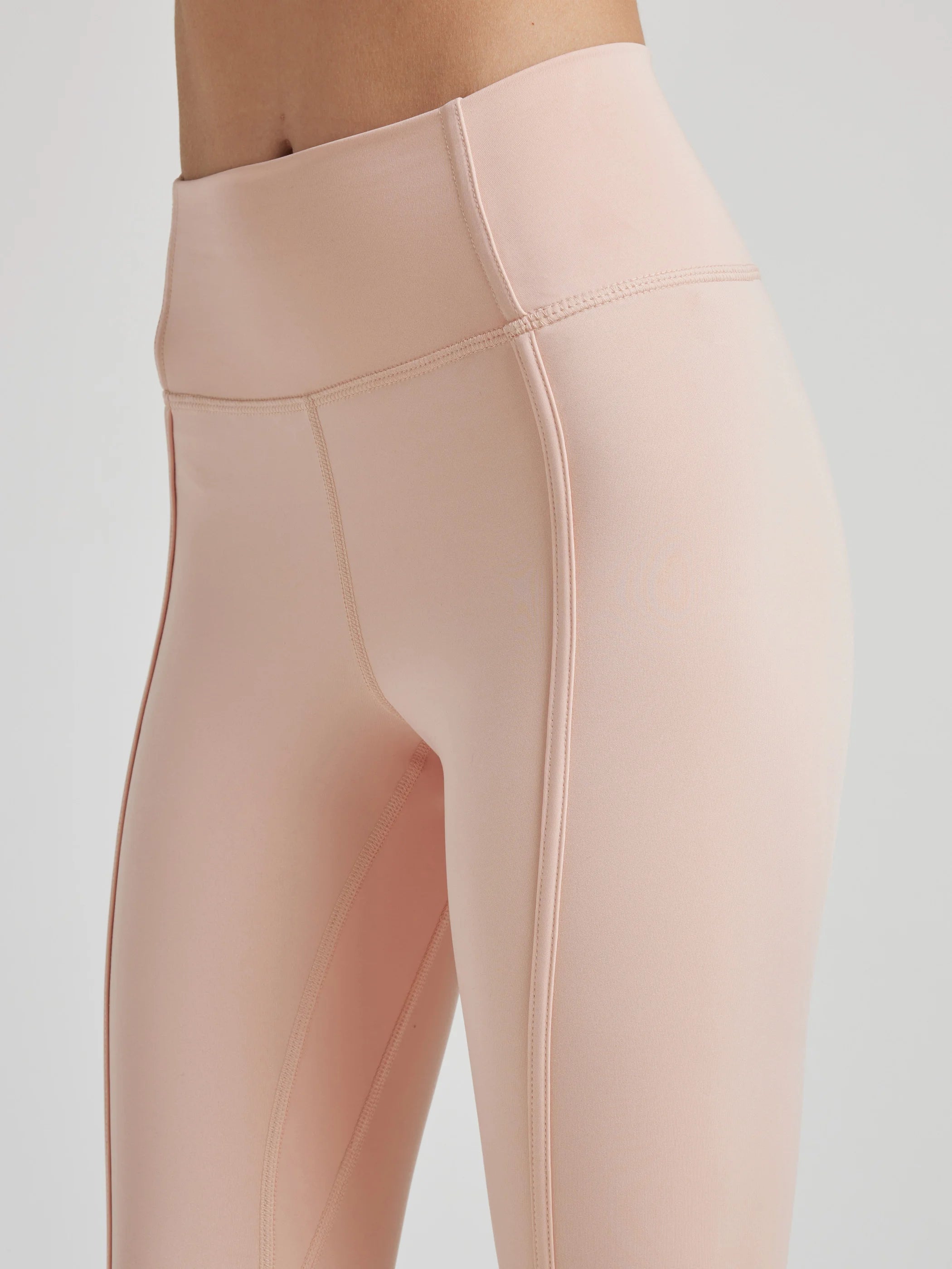 model poses in ballet-pink leggings with corset boning