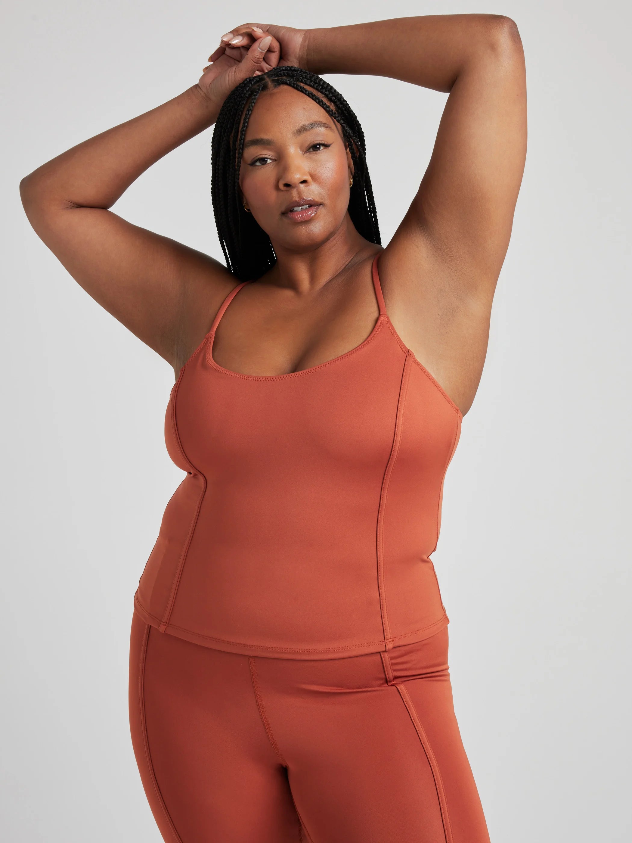 model poses in burnt orange corset tank