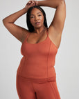 model poses in burnt orange corset tank