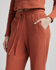 model wears relaxed waffle knit pants in baked clay