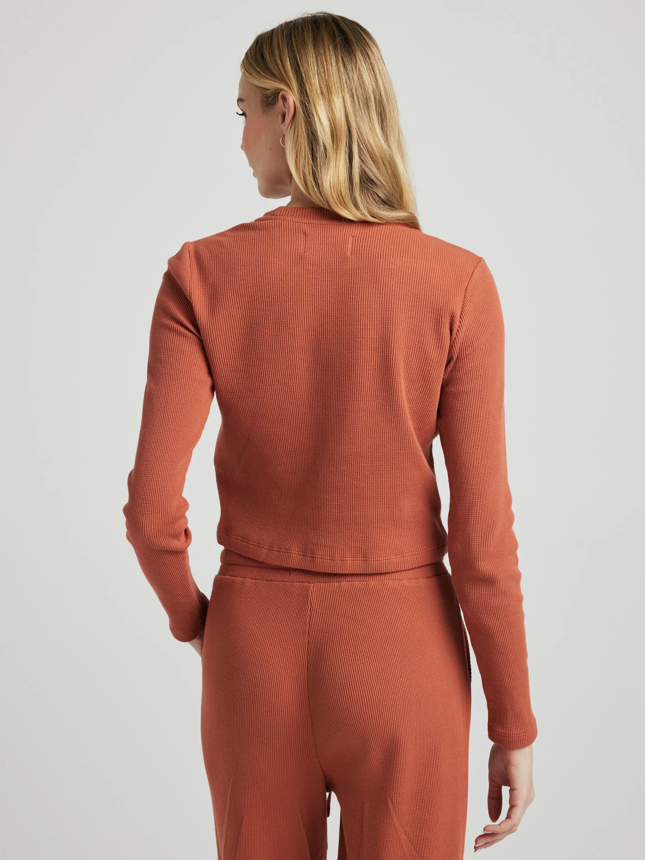 model wears organic thermal long sleeve in orange