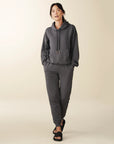 model wears cozy sustainable hoodie with pocket in grey