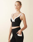 model wears cutest black and cream colorblock sports bra with adjustable straps